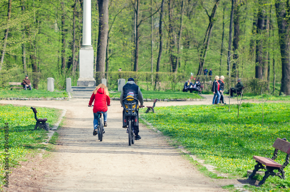 A group of cyclists ride in the city park