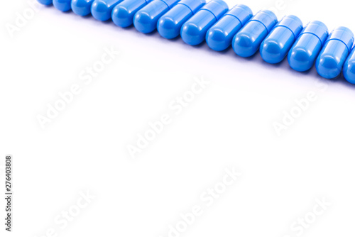 Blue capsules arranged in a row on top of the photo on a white background.