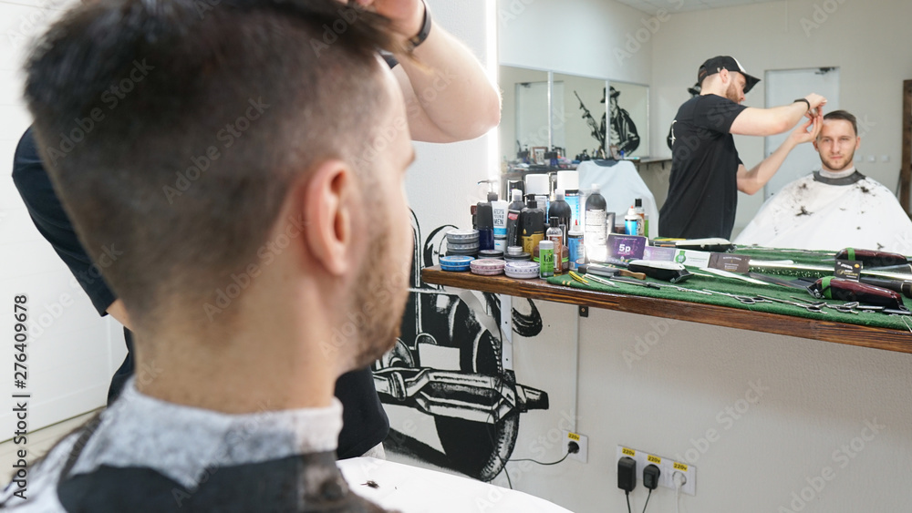 Barber cutting young man hair with clipper.Men's grooming trimmer in a beauty salon. Hair dressing concept. Barber cutting young man hair with clipper.Men's grooming trimmer in a beauty salon. Hair dressing concept.