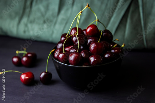 cherries in black containers on the table