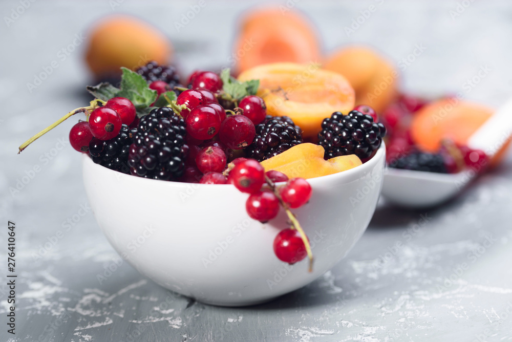The explosion of different berries. Photo, red currant, black currant, blackberry, apricot on a concrete background. The explosion of different berries. Photo, red currant, black currant, blackberry, apricot on a concrete background.