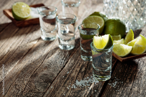 Tequila with salt and lime on a old wooden background.