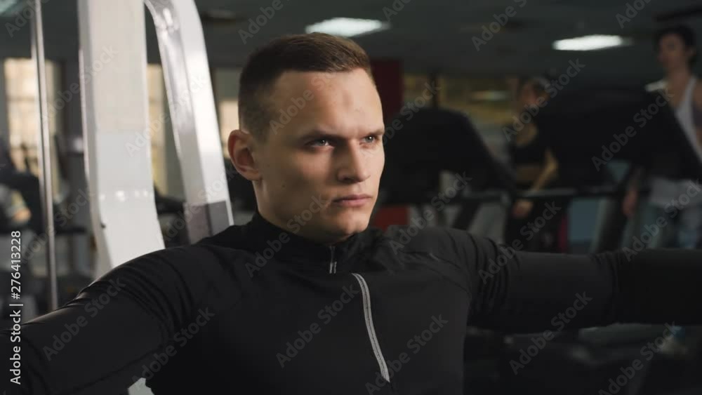 Concentrated man doing exercises in the gym. A man training in the gym after work. Concentrated man doing exercises in the gym. A man training in the gym after work.
