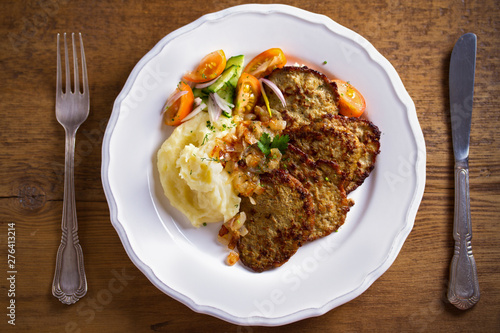 Chicken liver pancakes with mashed potato and vegetables on white plate. Liver side dish