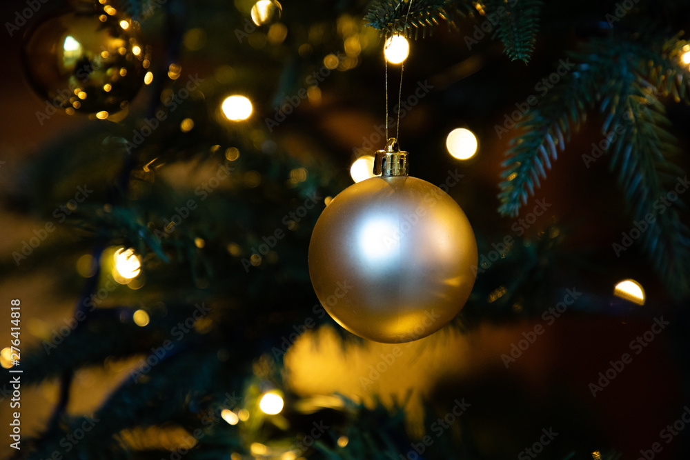Golden decoration globe on christmas tree close up Golden decoration globe on christmas tree close up