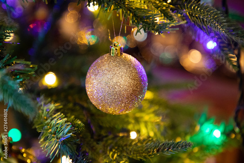 Golden decoration globe on christmas tree close up
