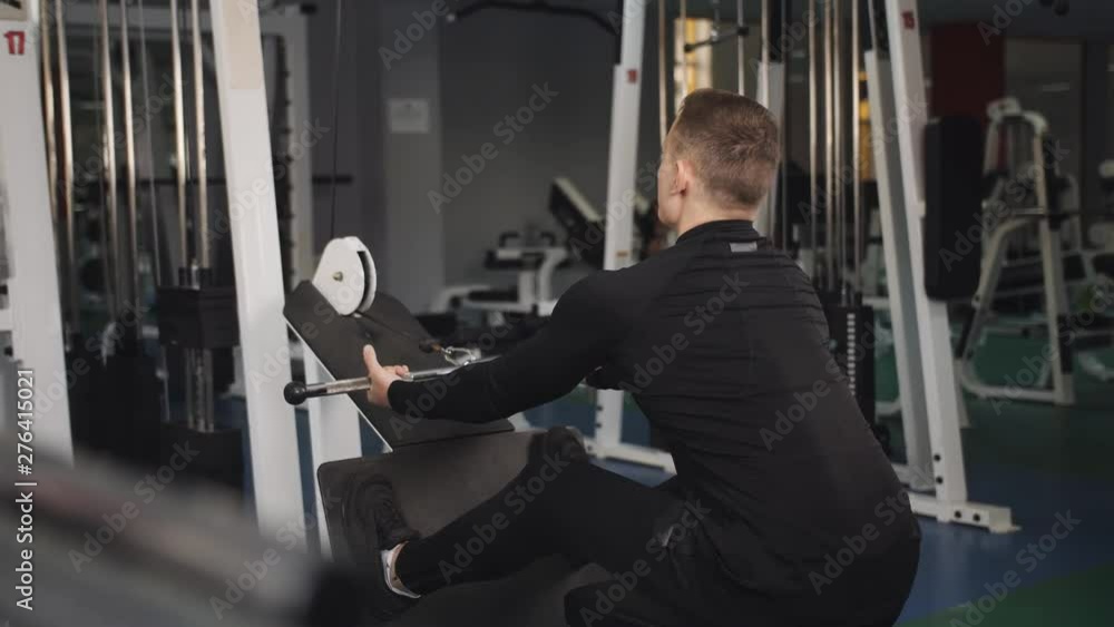 Man adjusting tricep machine before doing arms workout in gym Man adjusting tricep machine before doing arms workout in gym