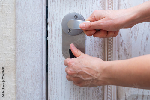 Obraz na plátně Woman closes door lock deadbolt