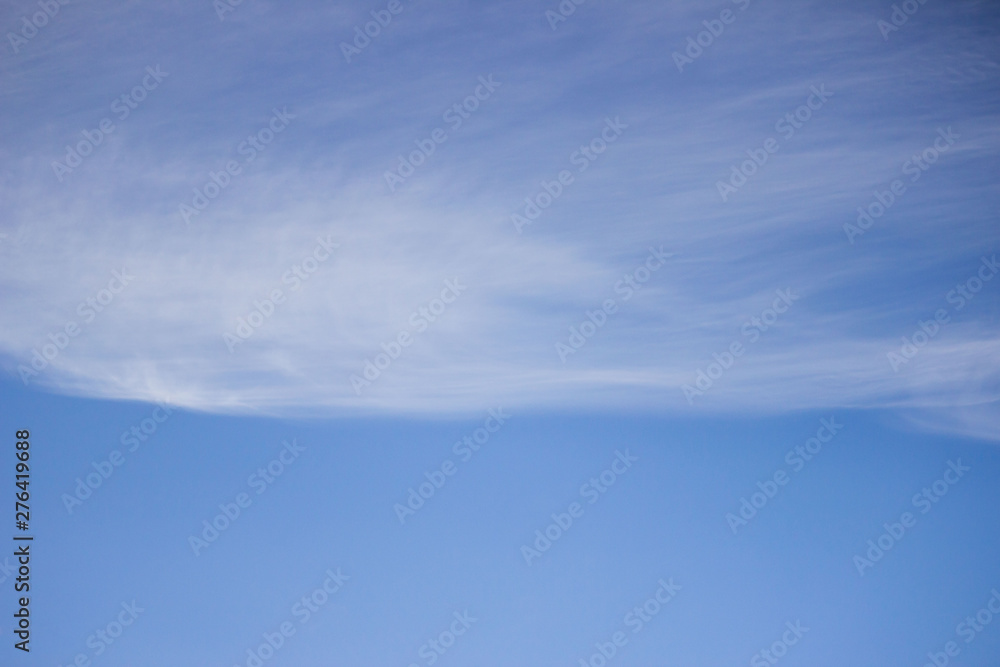 Blue sky with a large white translucent cloud. blue and white in half.