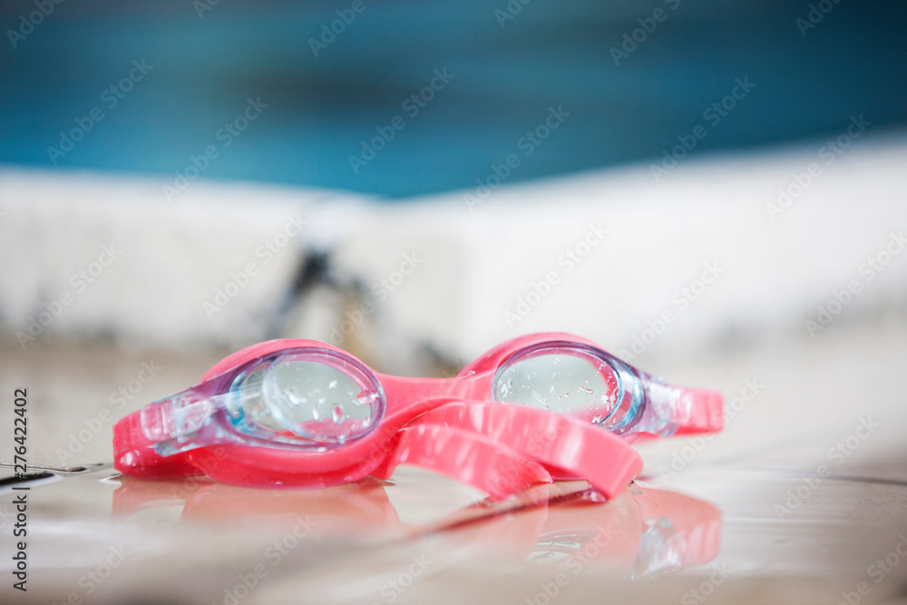 wet swimming goggles on the floor in a indoor pool