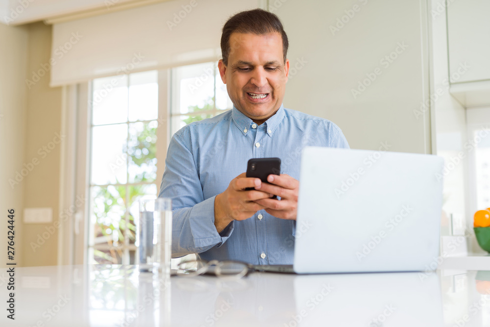 Middle age man working with laptop and using smartphone Middle age man working with laptop and using smartphone