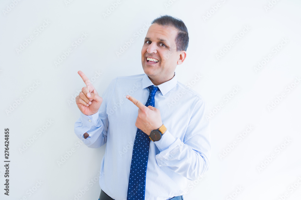 Middle age business man smiling and pointing to the side over white background Middle age business man smiling and pointing to the side over white background