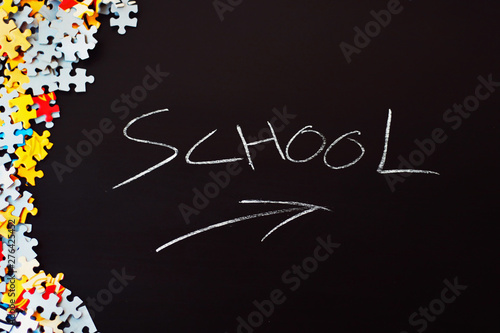 Black background with the word school and some puzzle pieces.