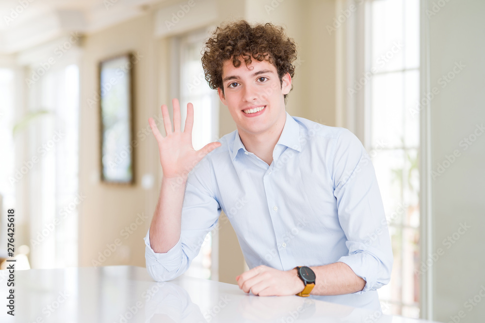 Young business man with curly read head showing and pointing up with fingers number five while smiling confident and happy.