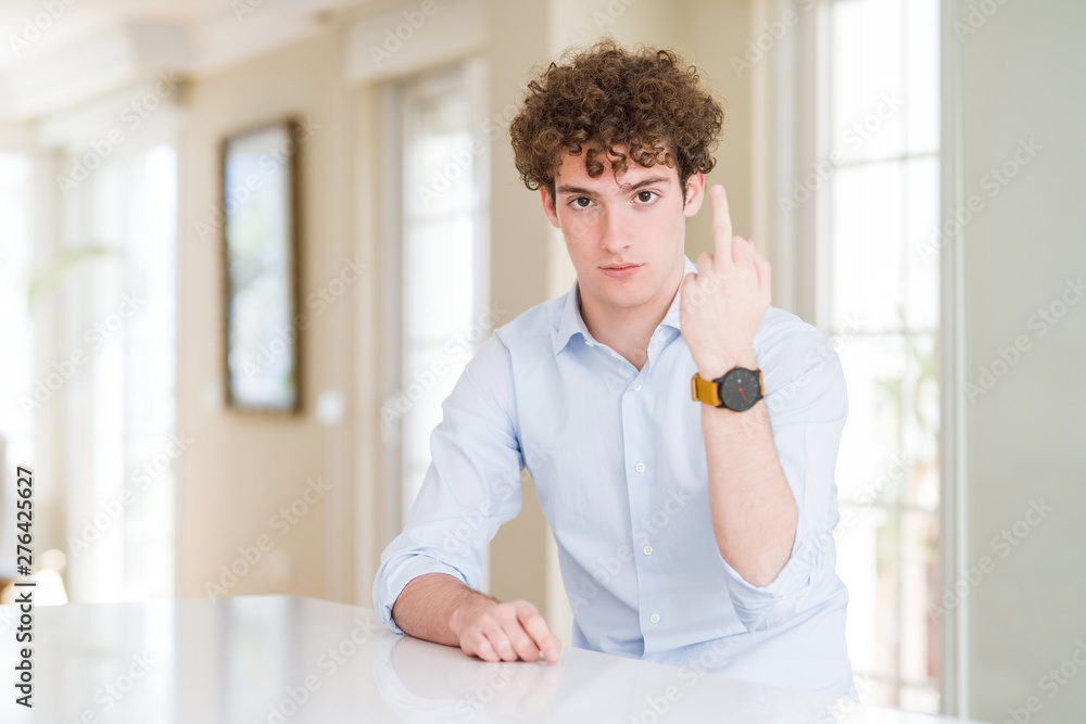 Young business man with curly read head Showing middle finger, impolite and rude fuck off expression Young business man with curly read head Showing middle finger, impolite and rude fuck off expression