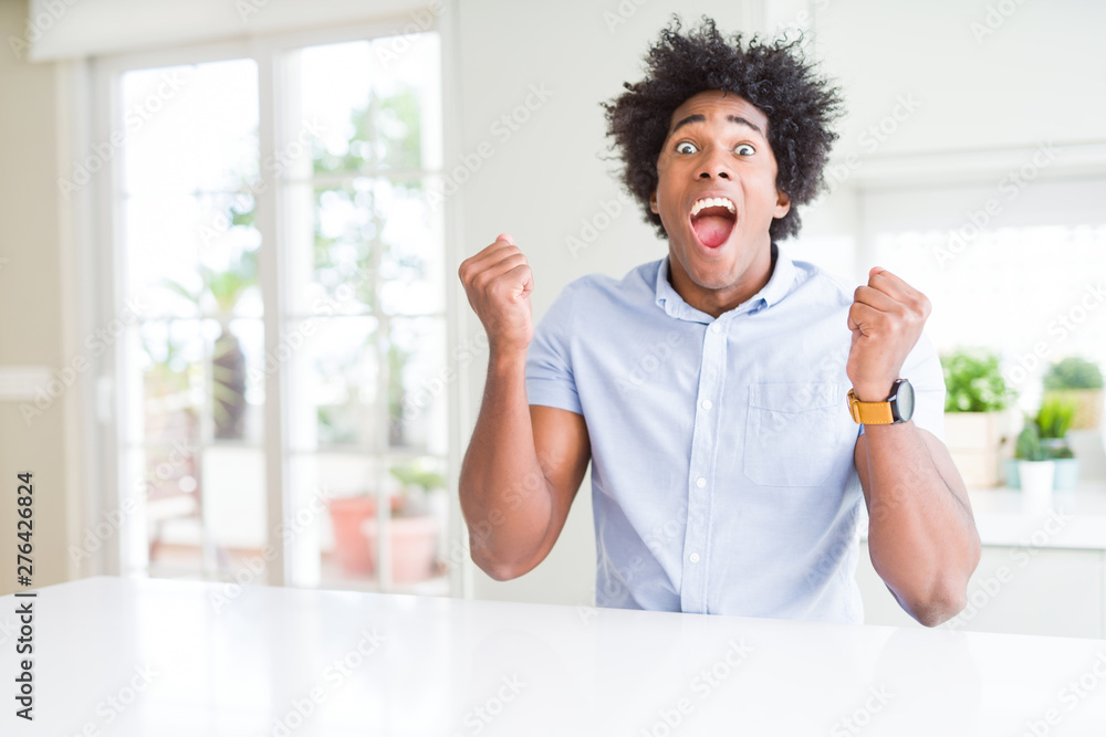 African American business man celebrating surprised and amazed for success with arms raised and open eyes. Winner concept. African American business man celebrating surprised and amazed for success with arms raised and open eyes. Winner concept.