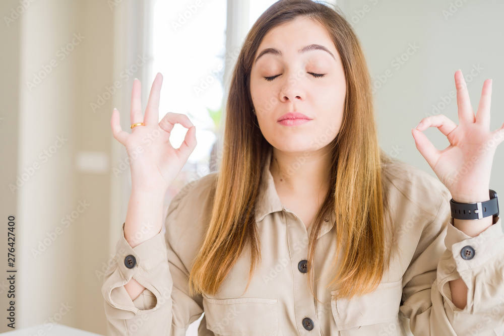 Beautiful young woman at home relax and smiling with eyes closed doing meditation gesture with fingers. Yoga concept. Beautiful young woman at home relax and smiling with eyes closed doing meditation gesture with fingers. Yoga concept.