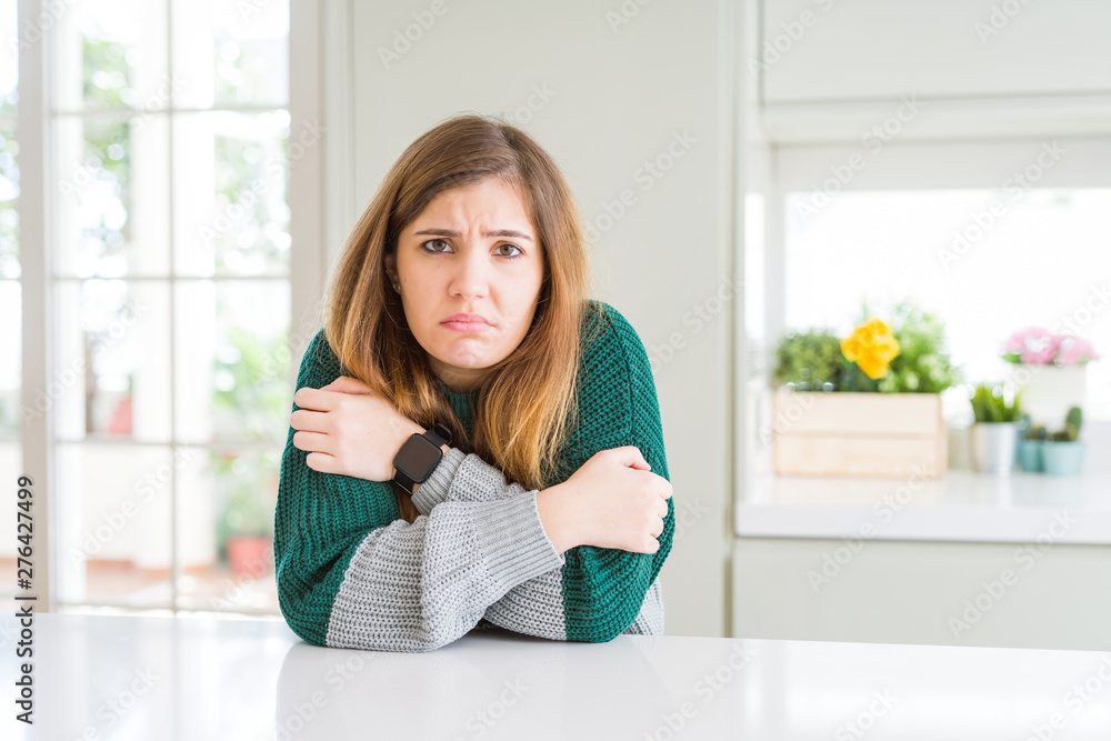 Young beautiful plus size woman wearing casual striped sweater shaking and freezing for winter cold with sad and shock expression on face