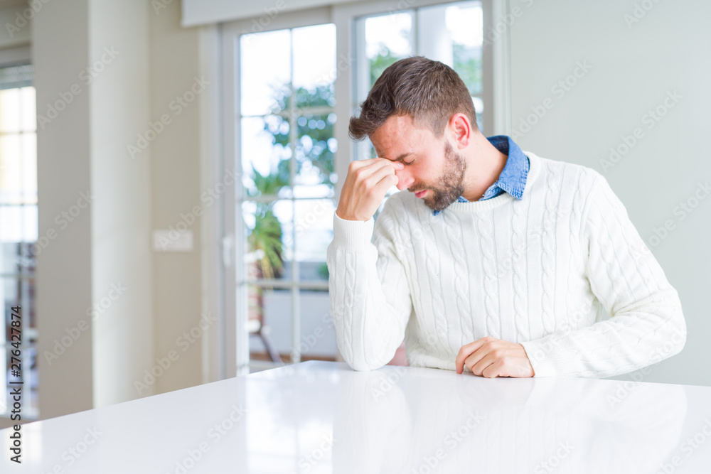 Handsome man wearing casual sweater tired rubbing nose and eyes feeling fatigue and headache. Stress and frustration concept.