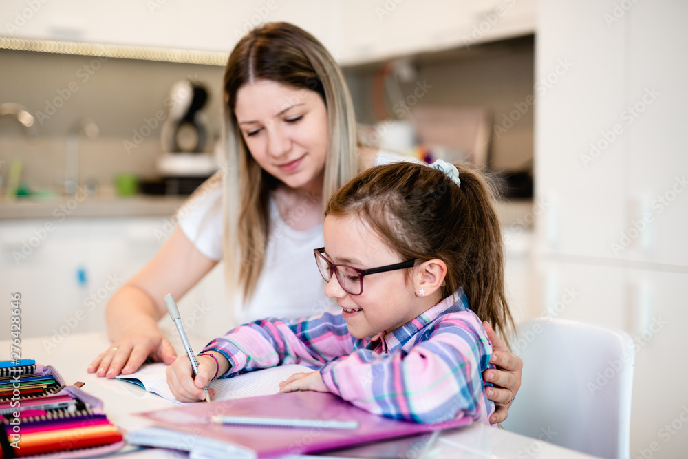 Beautiful young woman is helping her younger sister with homework. Beautiful young woman is helping her younger sister with homework.