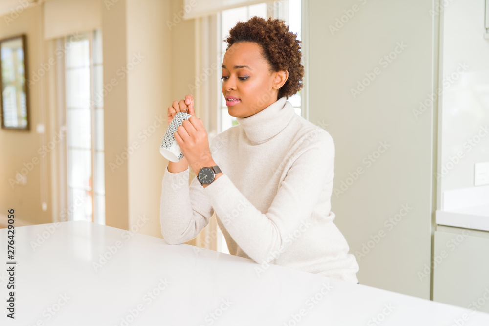 Beautiful young african american woman with afro hair drinking a cup of coffee at home Beautiful young african american woman with afro hair drinking a cup of coffee at home