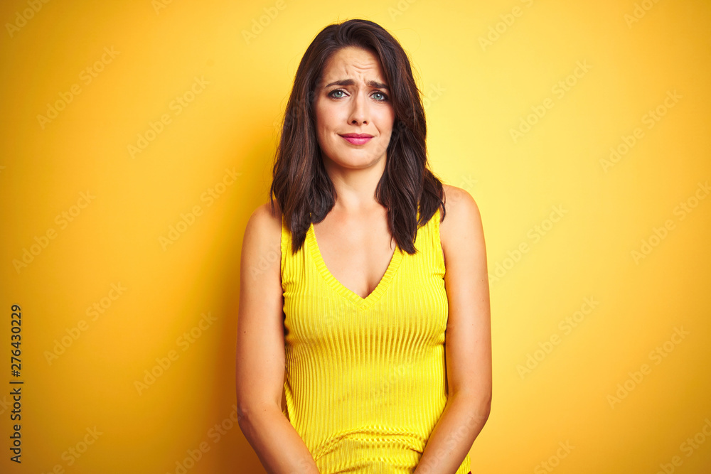 Obraz premium Young beautiful woman wearing t-shirt standing over yellow isolated background depressed and worry for distress, crying angry and afraid. Sad expression.