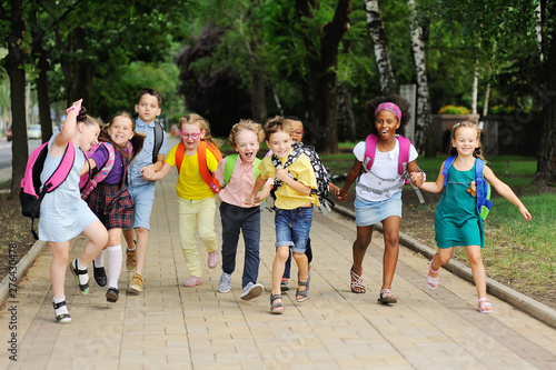 Fotografie small schoolchildren with colorful school bags and backpacks run to school