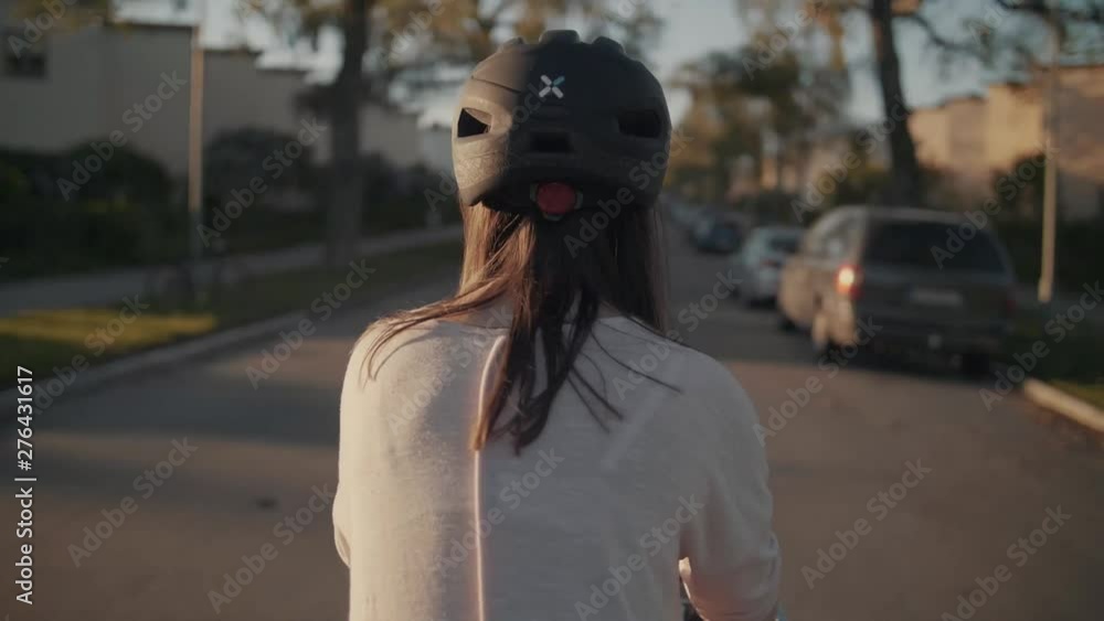 Girl on bike. Frame shot during golden hour, The girl is walking on a Stockholm street, Sweden, filmed from behind, slow motion Girl on bike. Frame shot during golden hour, The girl is walking on a Stockholm street, Sweden, filmed from behind, slow motion