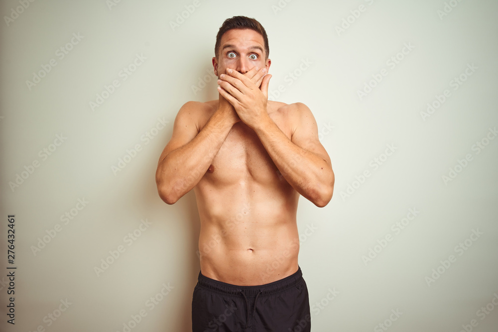 Fototapeta premium Young handsome shirtless man over isolated background shocked covering mouth with hands for mistake. Secret concept.