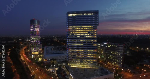 Aerial shot over Bucharest’s northern area. Evening / night shot with gorgeous red sky in a very important area of corporate buildings from Bucharest with tall, glass, modern skyscrapers.  photo