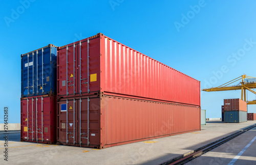 Logistics , transportation of Container Cargo freight ship with working crane bridge in shipyard. Smart logistic import export and transport industry concept with flare light.