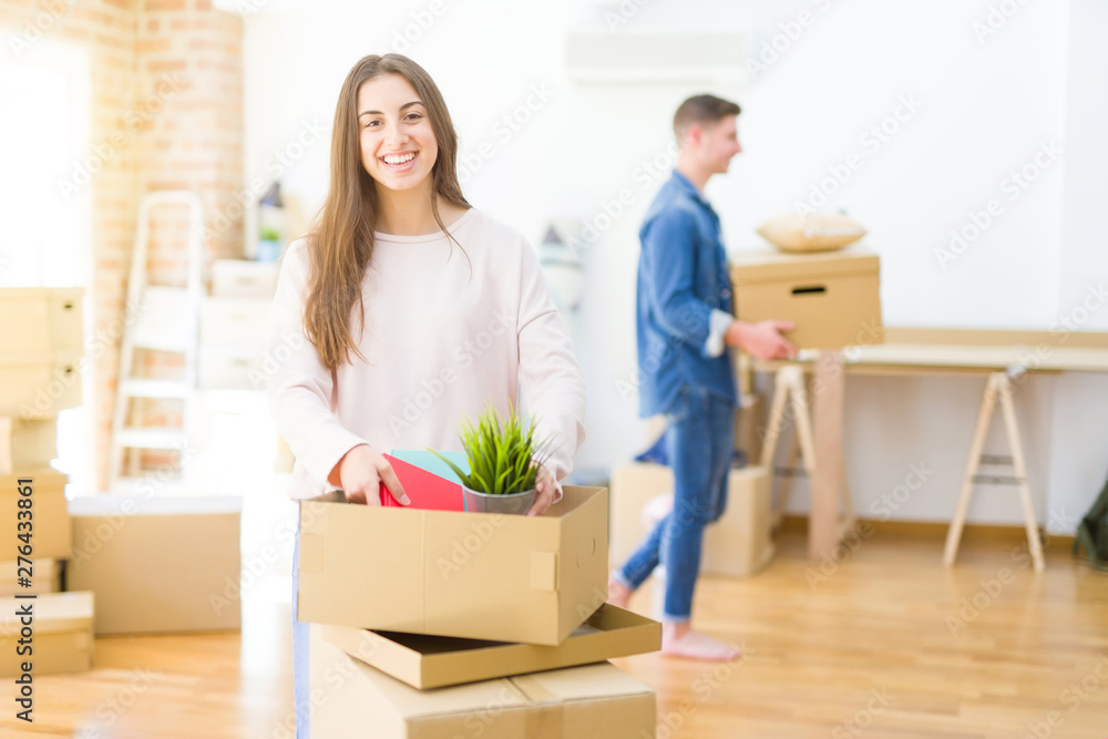Beautiful young couple smiling in love holding cardboard boxes, happy for moving to a new home Beautiful young couple smiling in love holding cardboard boxes, happy for moving to a new home