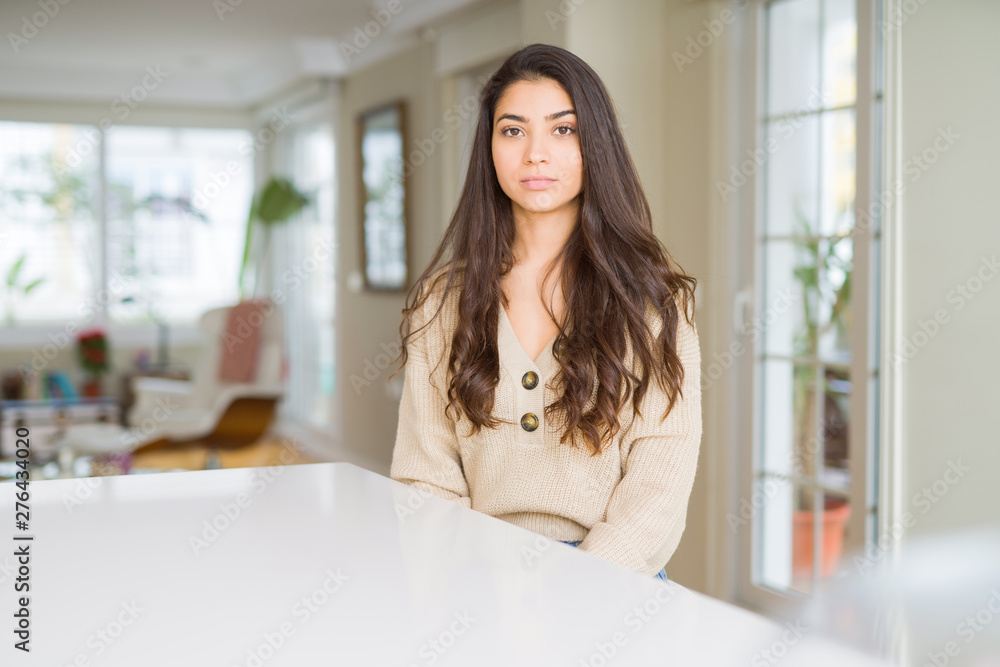 Young beautiful woman at home with serious expression on face. Simple and natural looking at the camera. Young beautiful woman at home with serious expression on face. Simple and natural looking at the camera.