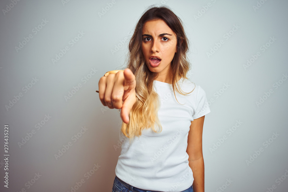 Young beautiful woman wearing casual white t-shirt over isolated background pointing displeased and frustrated to the camera, angry and furious with you Young beautiful woman wearing casual white t-shirt over isolated background pointing displeased and frustrated to the camera, angry and furious with you