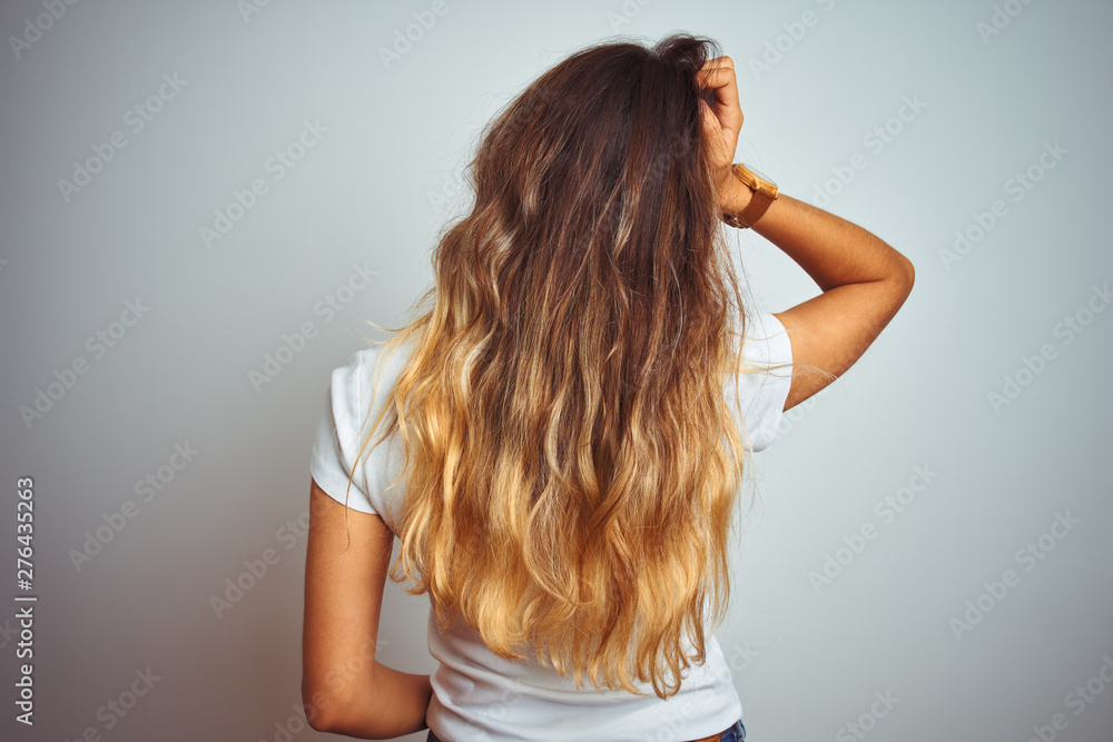 Young beautiful woman wearing casual white t-shirt over isolated background Backwards thinking about doubt with hand on head Young beautiful woman wearing casual white t-shirt over isolated background Backwards thinking about doubt with hand on head