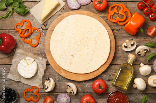 Flat lay composition pizza crust and fresh ingredients on wooden table