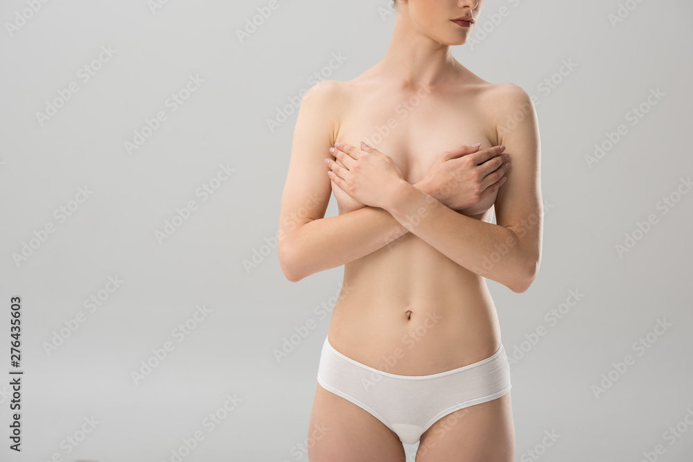 cropped view of sexy topless girl in panties covering breast isolated on grey cropped view of sexy topless girl in panties covering breast isolated on grey