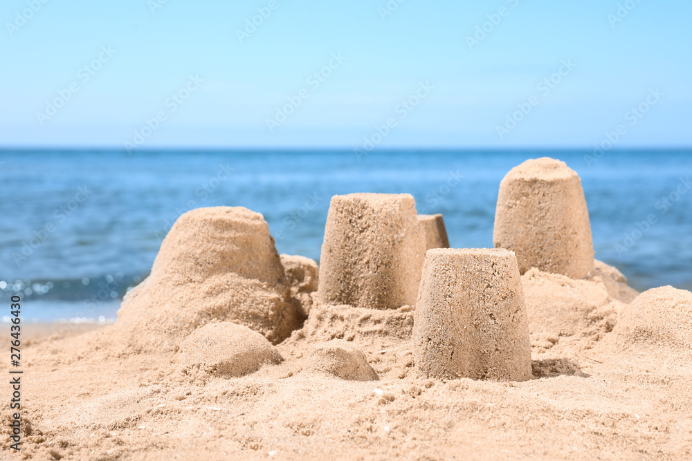 Little sand figures on beach near sea