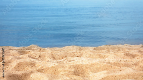 View of sea water and beach sand on sunny summer day