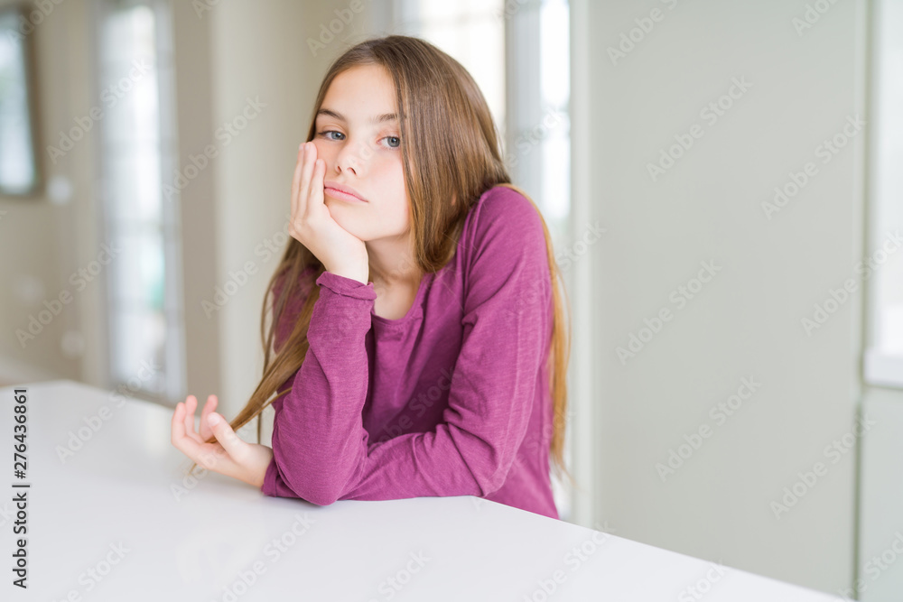 Beautiful young girl kid on white table thinking looking tired and bored with depression problems with crossed arms. Beautiful young girl kid on white table thinking looking tired and bored with depression problems with crossed arms.