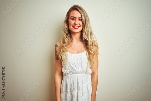 Young beautiful woman wearing casual dress standing over white isolated background with a happy and cool smile on face. Lucky person.