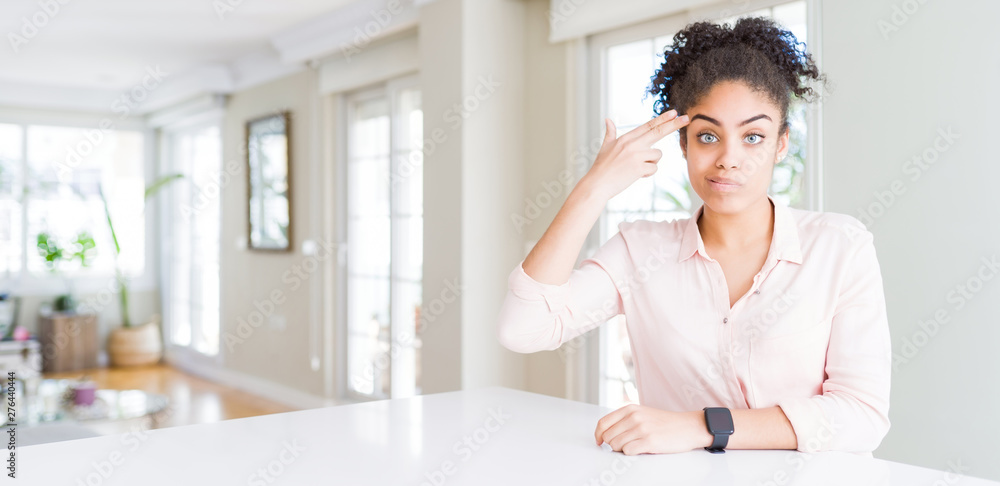 Wide angle of beautiful african american woman with afro hair Shooting and killing oneself pointing hand and fingers to head like gun, suicide gesture. Wide angle of beautiful african american woman with afro hair Shooting and killing oneself pointing hand and fingers to head like gun, suicide gesture.