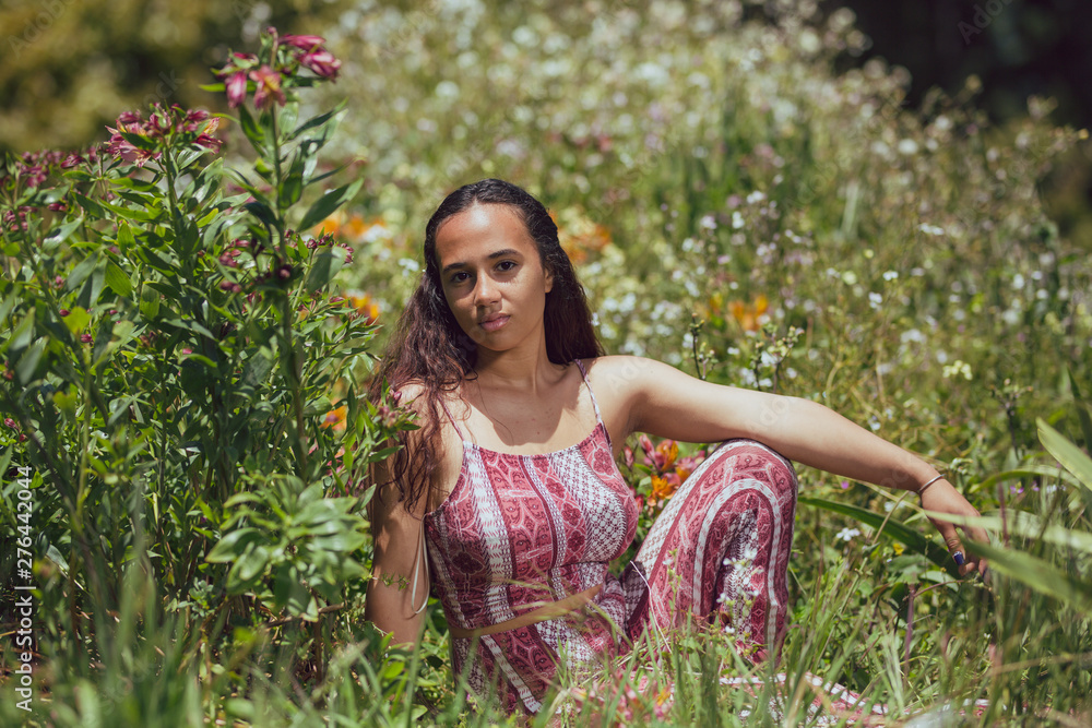 Mixed race young woman reclines in grass on a farm Mixed race young woman reclines in grass on a farm