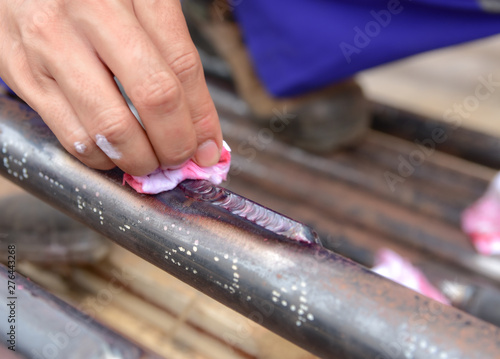 Workers are remove the penetrant from the workpiece.This is the second step of Penetrant Testing (PT).