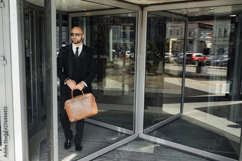 businessman with a bag near the office talking on the phone