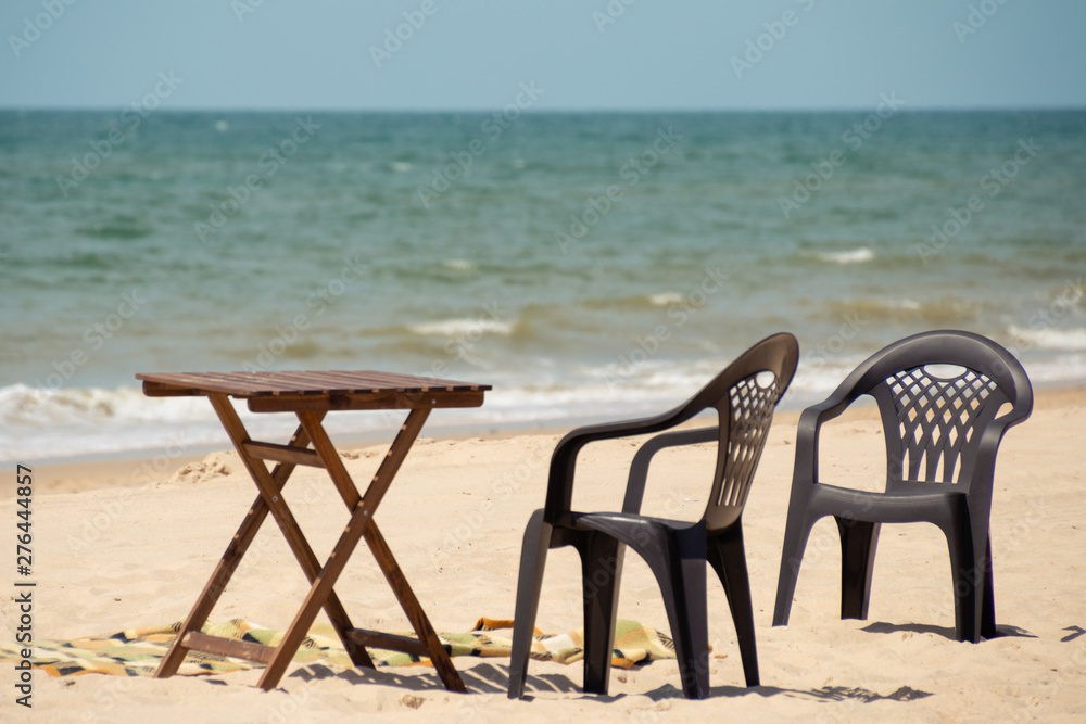 Sunny beach on the sea. Beach chairs and a table waiting for tourists