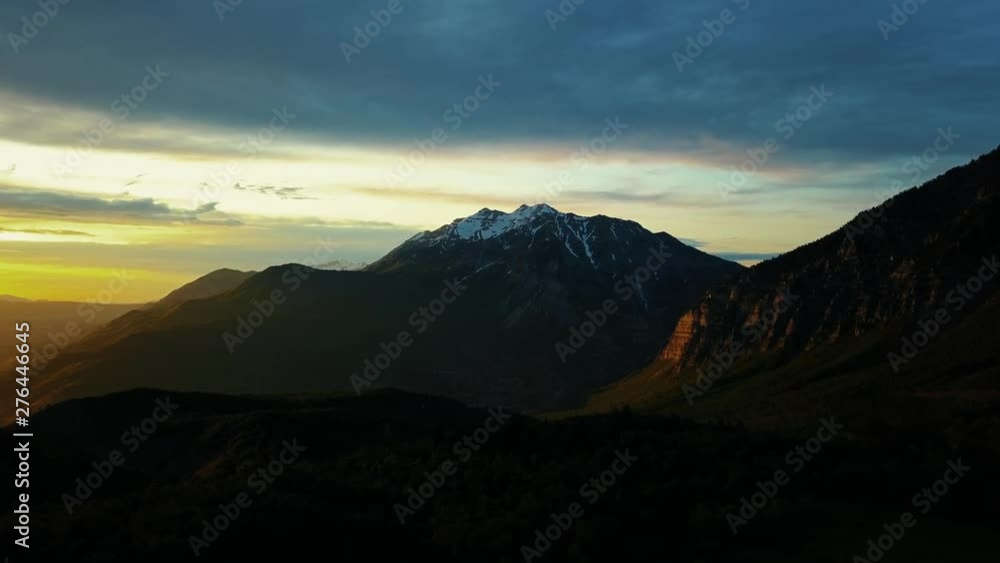 Beautiful vibrant sunset with the large and rugged Mount Timpanogos in the background which is part of the Rocky Mountain range located in Utah Valley, USA. Beautiful vibrant sunset with the large and rugged Mount Timpanogos in the background which is part of the Rocky Mountain range located in Utah Valley, USA.