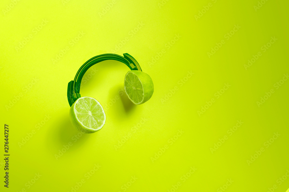 Fototapeta Zielone słuchawki cytrusowe. Kreatywna koncepcja na letnie imprezy.
