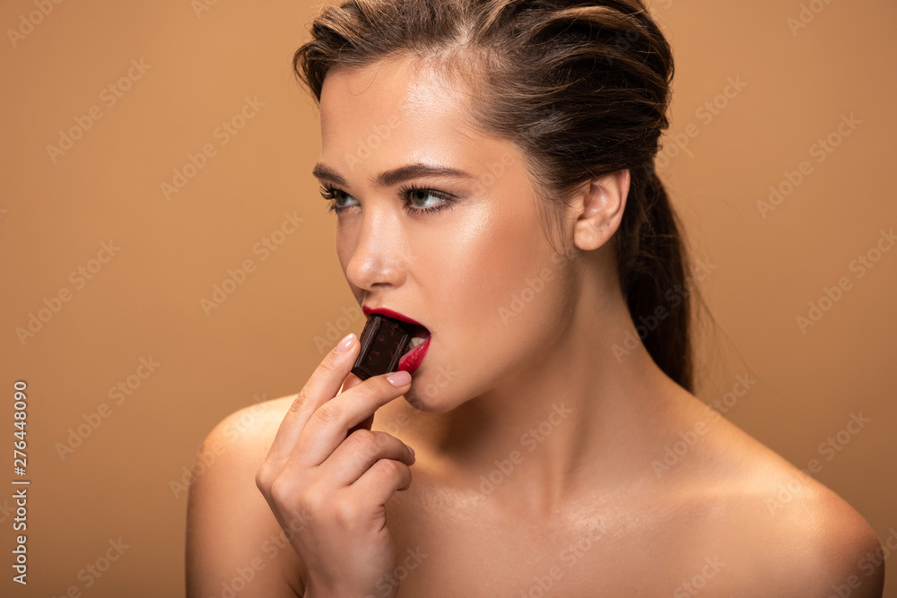 beautiful naked woman eating chocolate piece isolated on beige beautiful naked woman eating chocolate piece isolated on beige
