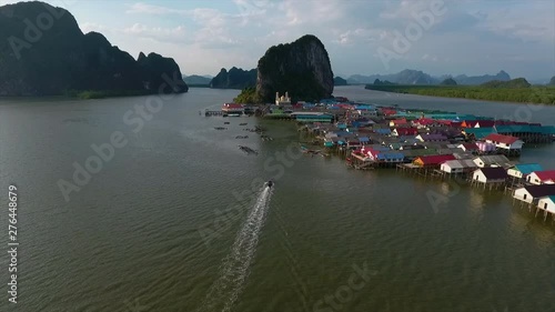 An establishing shot of boats sailing back to a settlement surrounded by water in Thailand